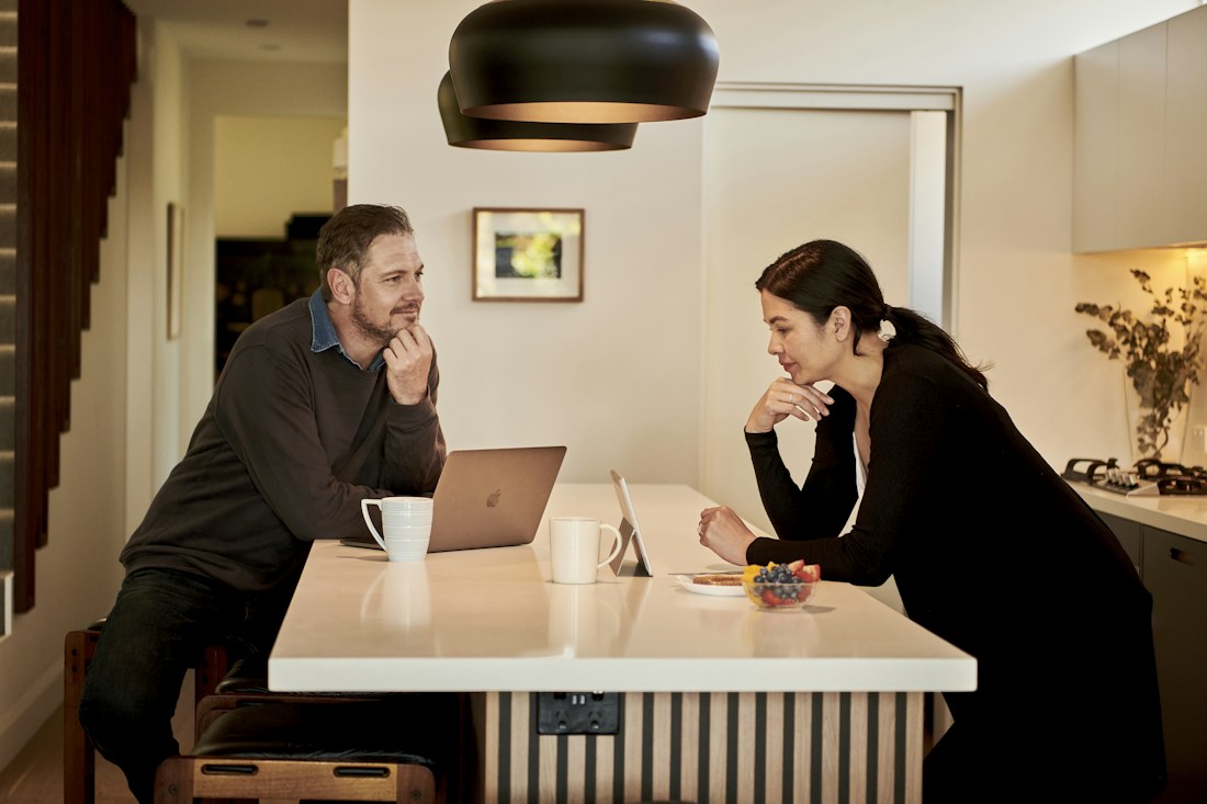Two people considering their options at a kitchen table